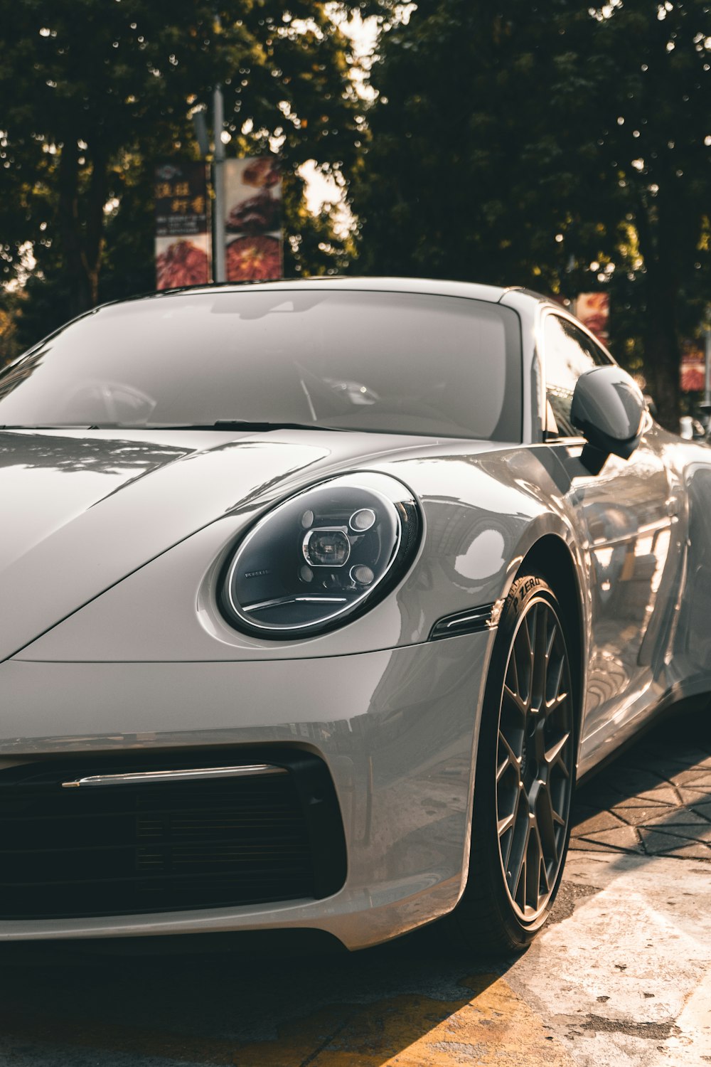 Silberner Porsche 911 tagsüber auf der Straße geparkt