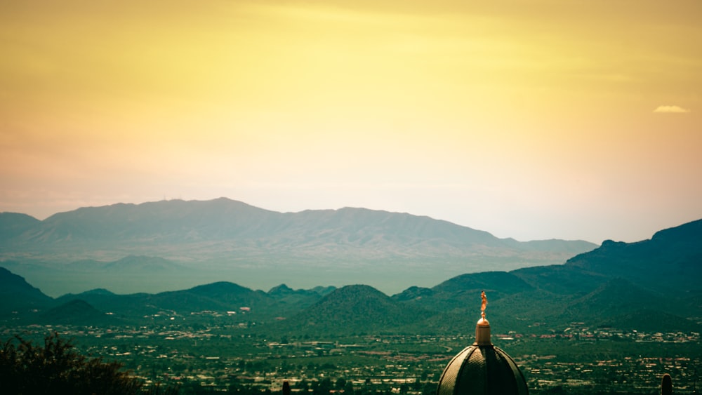 white and brown dome building near green mountains during daytime