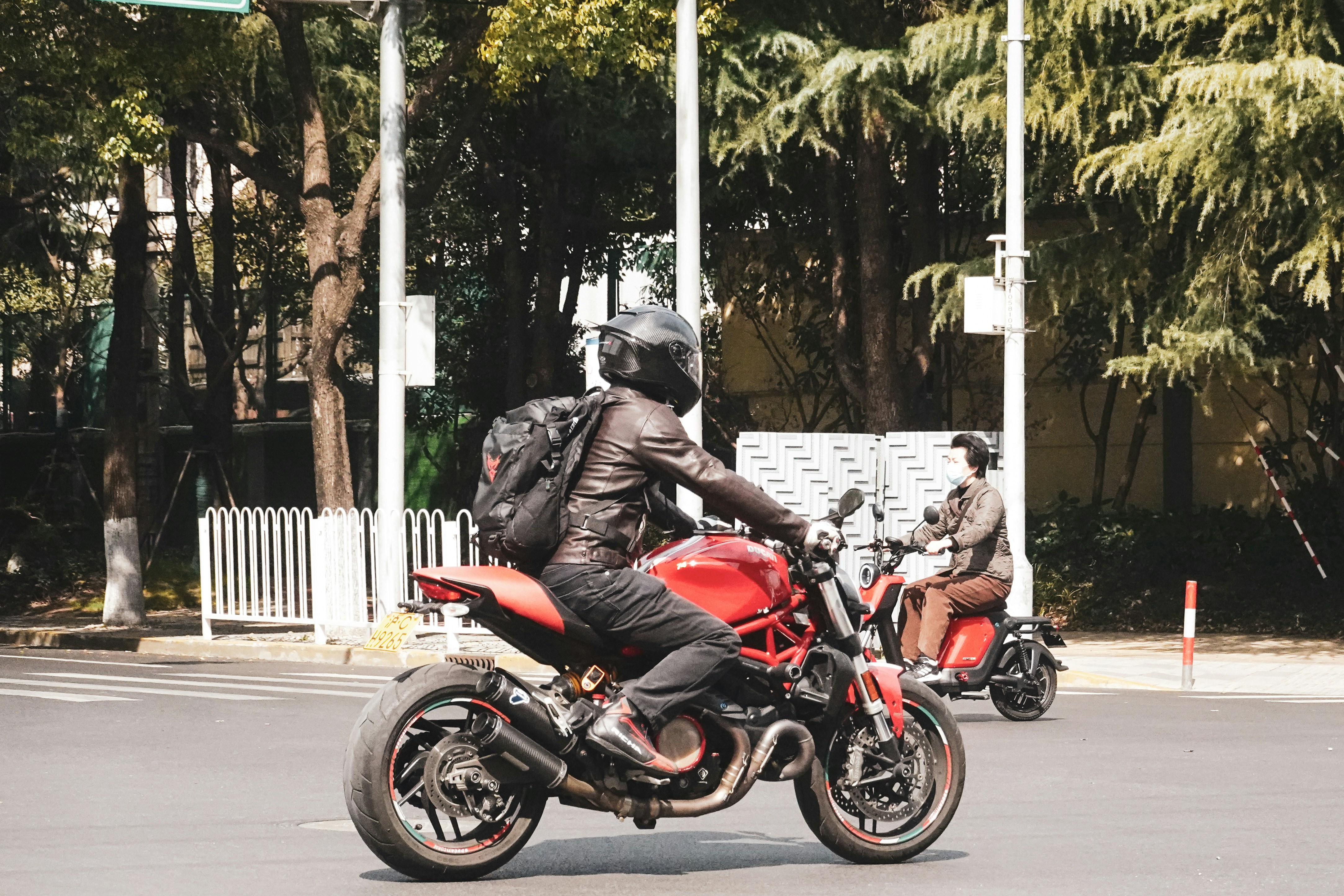 man in red jacket riding red motorcycle on road during daytime