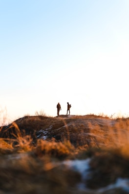 Braden and Cuzco standing on a rocky overlook with a vast Texas hill country view at sunset.