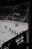 A small group practicing roller hockey drills on an outdoor rink.