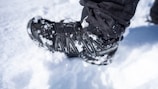 Close-up of a cozy winter boot on a snowy path.