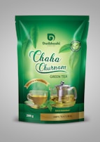 A green tea package with branding that includes images of a glass cup of tea and a glass teapot with tea in them. The packaging is predominantly green with the brand name 'Dwibhashi' and product name 'Chaha Churnam' prominently displayed. The package highlights the tea's natural, antioxidant-rich qualities, and features imagery of fresh green tea leaves.