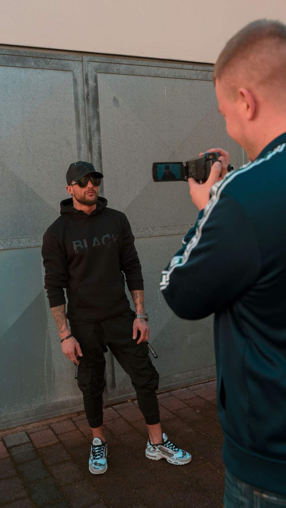 man in black sweater standing beside man in black jacket