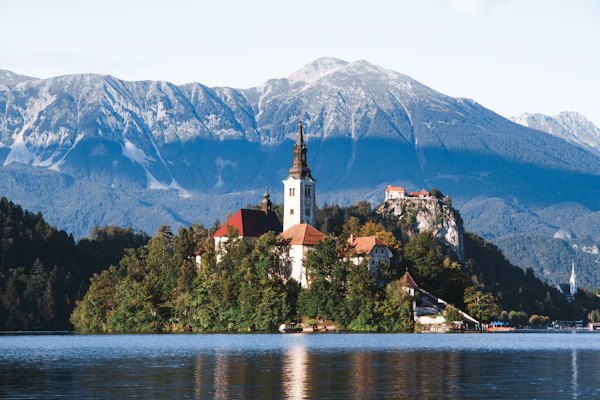 Brown and white concrete building near body of water during daytime — Lake Bled, Slovenia