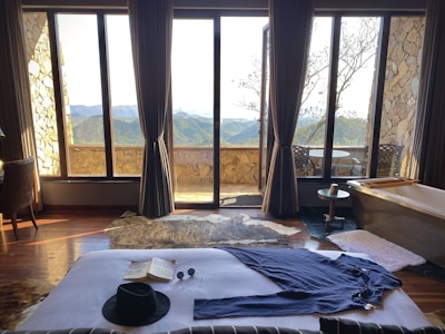 A cozy hotel room with a beautiful view of mountains outside the window.