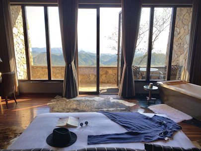 Cozy hotel room with warm lighting and a view of the Himalayan mountains through the window.