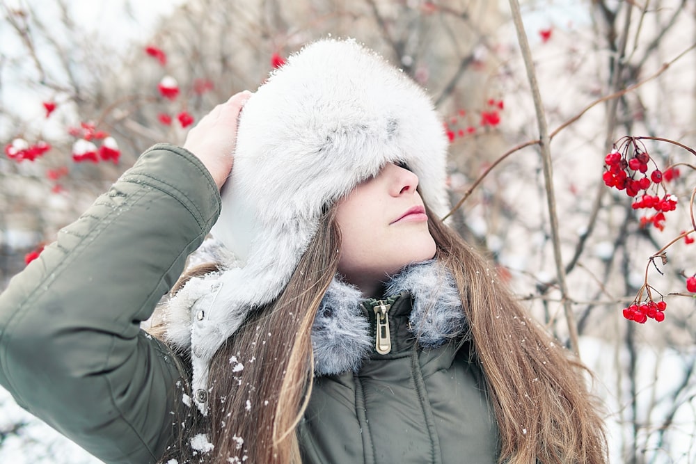 woman in green jacket wearing white fur scarf