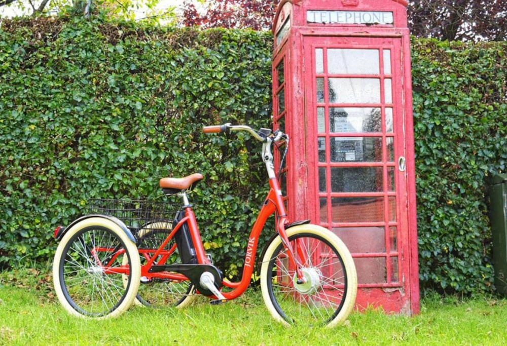 red bicycle parked beside red wooden door