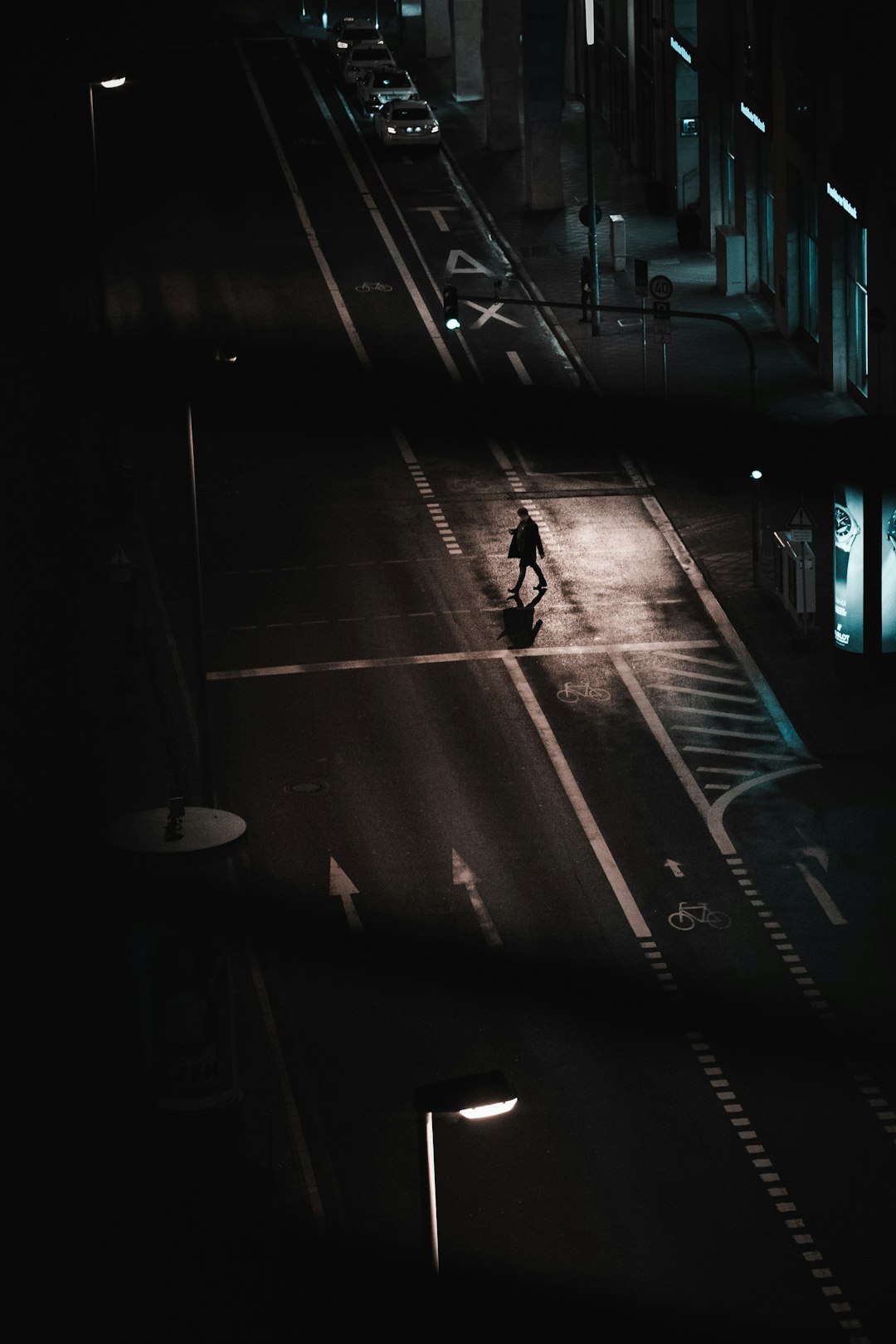 man walking on sidewalk during night time