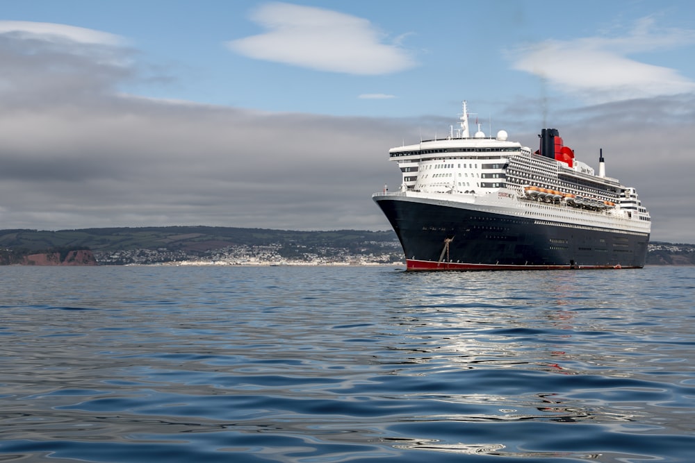 bateau de croisière blanc et noir sur la mer sous le ciel bleu pendant la journée