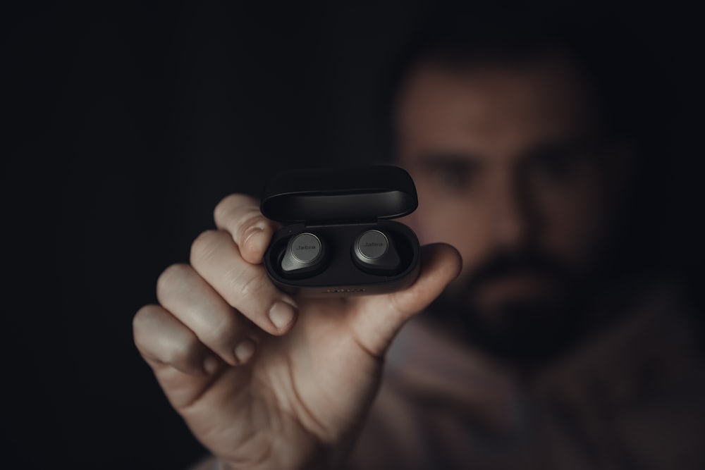 person holding black round device
