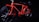 A vibrant red toy bicycle is displayed against a dark background. It features a detailed frame, with visible text on the top bar indicating 'MOVEMENT MAGIC POWER' and 'ELECTRICITY MOVES THE BICYCLE'. The bicycle includes two large wheels and a small attachment at the rear resembling a battery or motor pack.