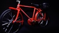 A vibrant red toy bicycle is displayed against a dark background. It features a detailed frame, with visible text on the top bar indicating 'MOVEMENT MAGIC POWER' and 'ELECTRICITY MOVES THE BICYCLE'. The bicycle includes two large wheels and a small attachment at the rear resembling a battery or motor pack.