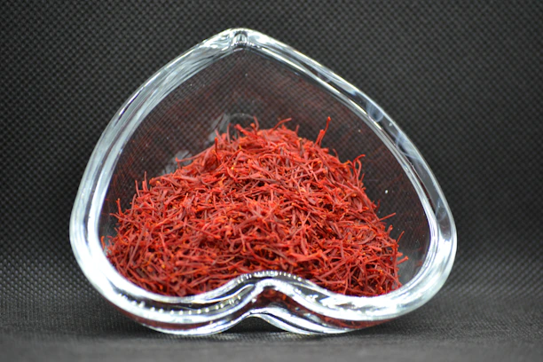 Close-up of vibrant saffron threads glowing against a dark, textured background.