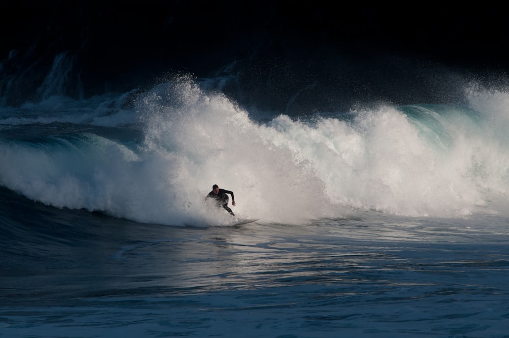 person surfing on sea waves during daytime