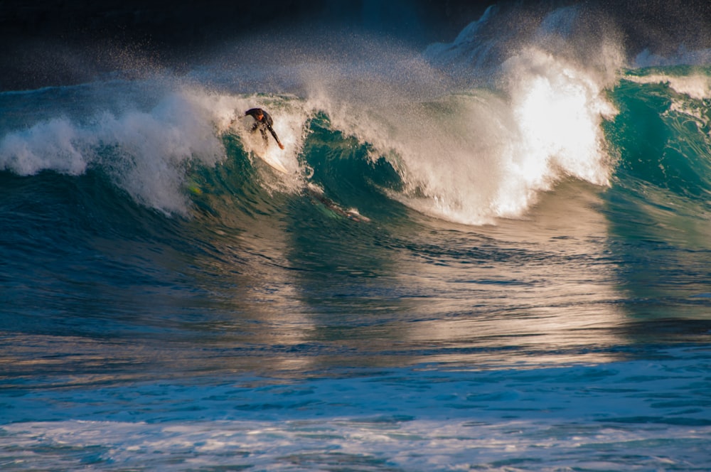 man surfing on sea waves during daytime