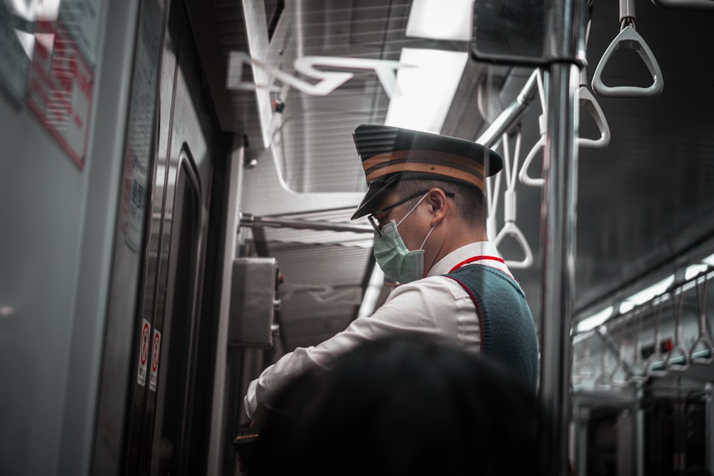 uomo in camicia bianca e gilet nero che indossa cappello nero