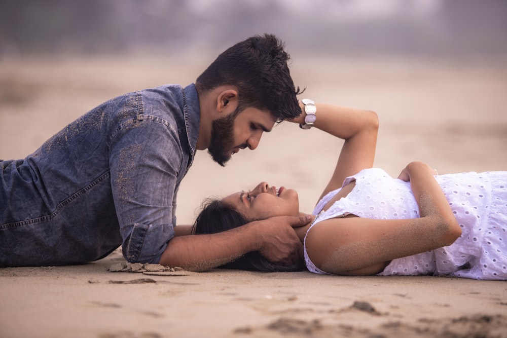 hombre y mujer besándose en la playa durante el día