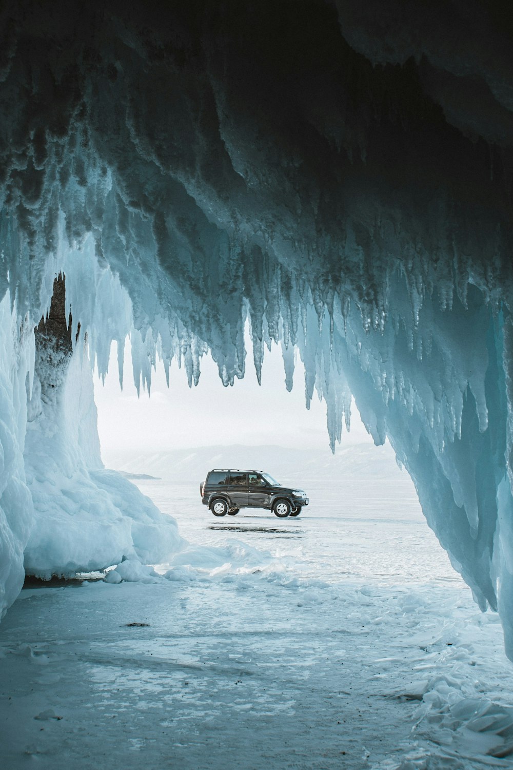 black car on snow covered road during daytime