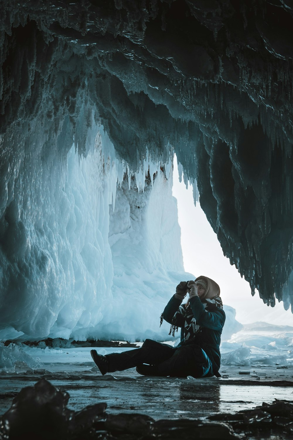 woman in black jacket sitting on snow covered ground