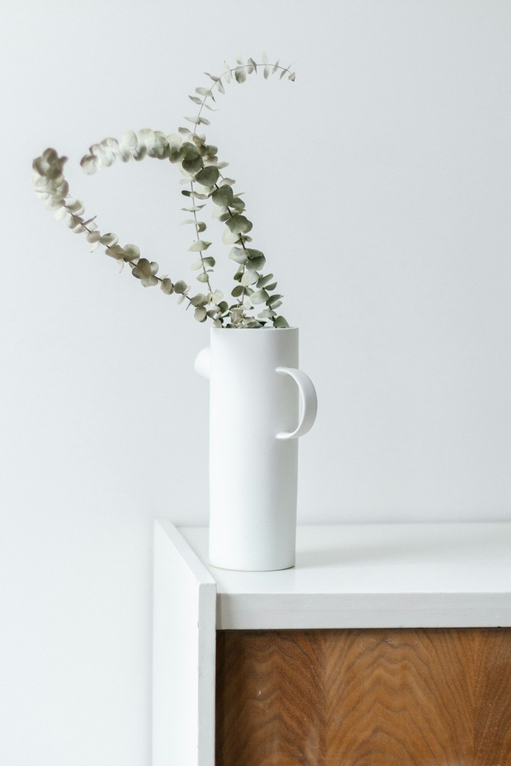 white ceramic mug on white wooden table