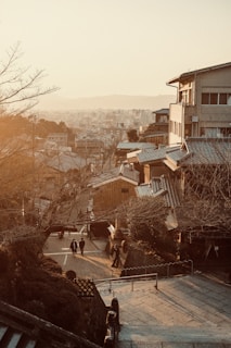 A peaceful street in a small Japanese town with cozy cafes and cherry blossom trees lining the sidewalk.