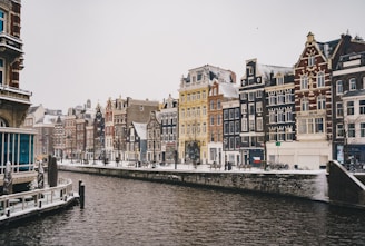 white and brown concrete buildings beside body of water during daytime