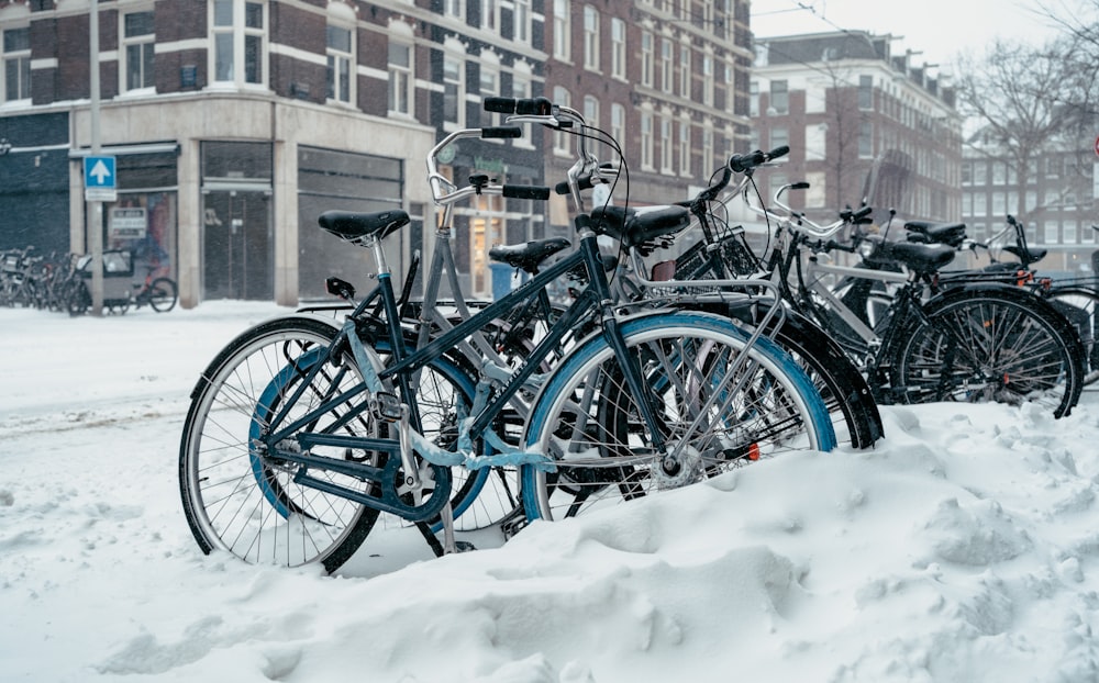 blue city bikes on snow covered ground during daytime
