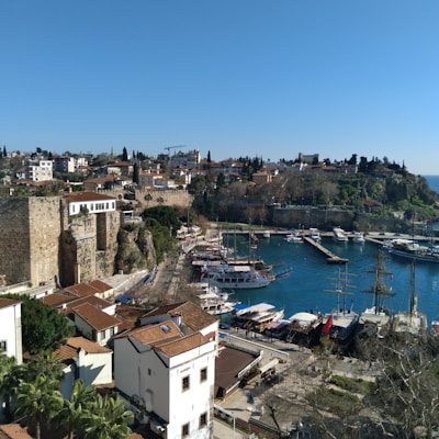 A picturesque Mediterranean harbor with multiple yachts and boats moored.