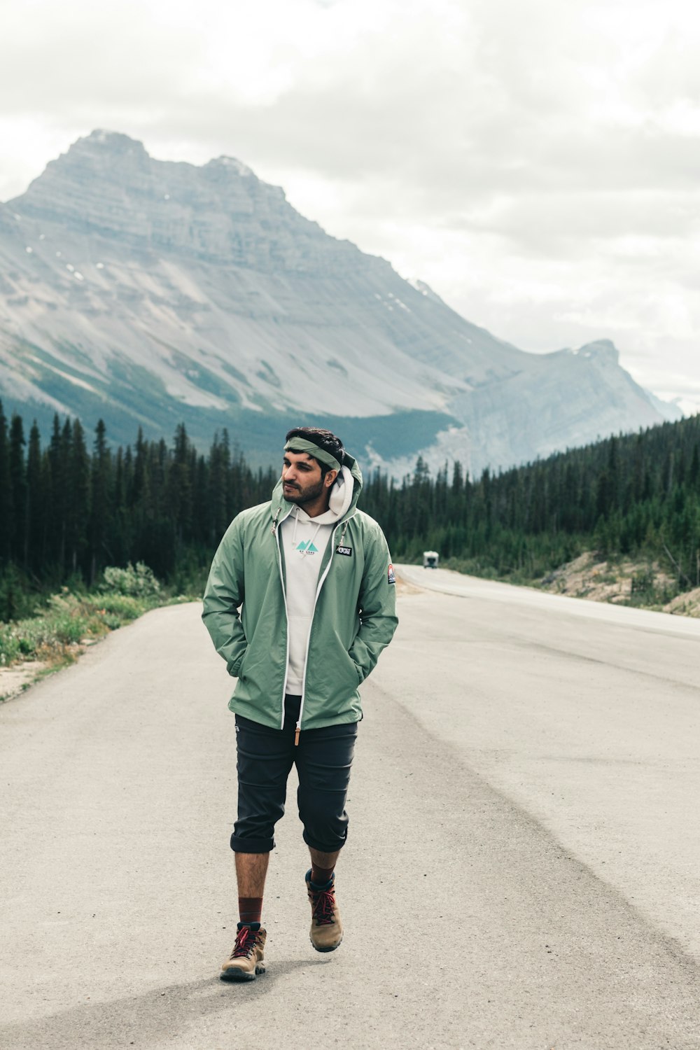 man in gray jacket standing on road during daytime