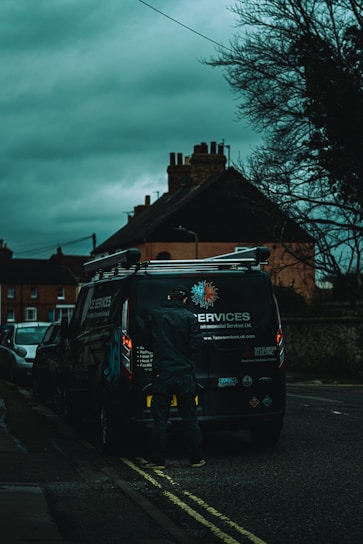 Photo of a friendly locksmith technician standing next to a branded service van.