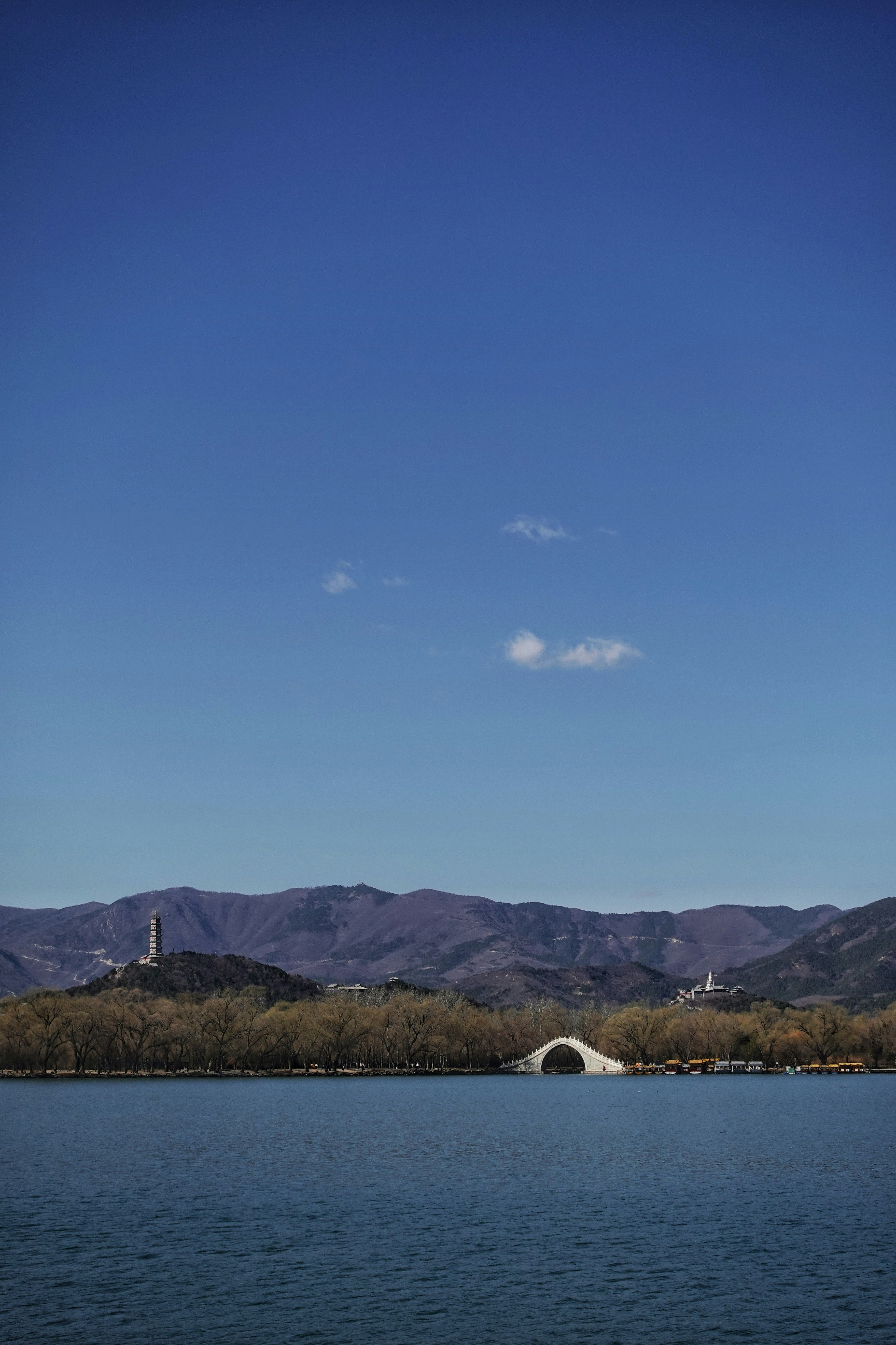 green grass field near mountain under blue sky during daytime