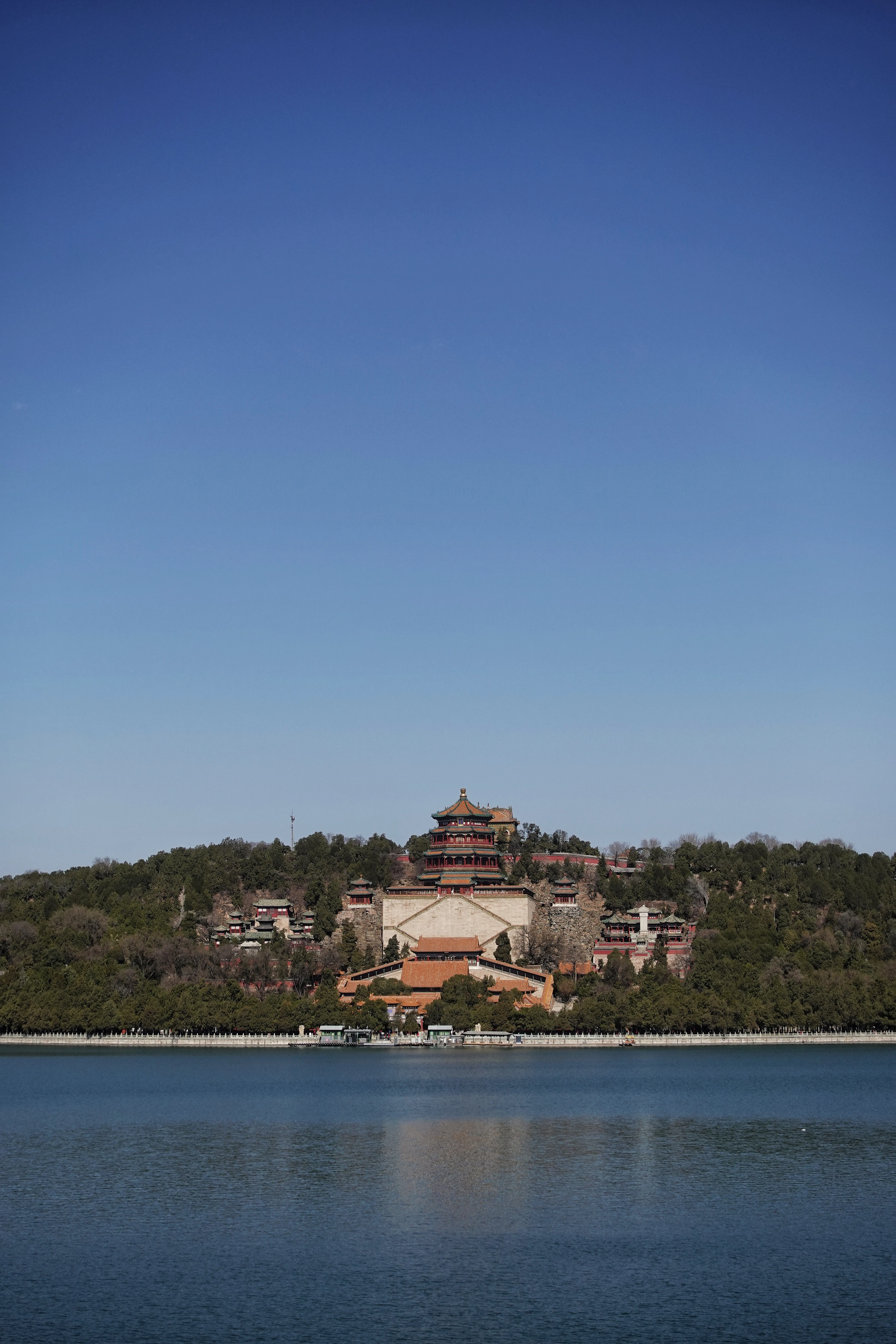 The Summer Palace's hilltop pavilions rise above Kunming Lake under a deep blue sky.