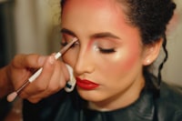 woman in red lipstick holding white cigarette stick