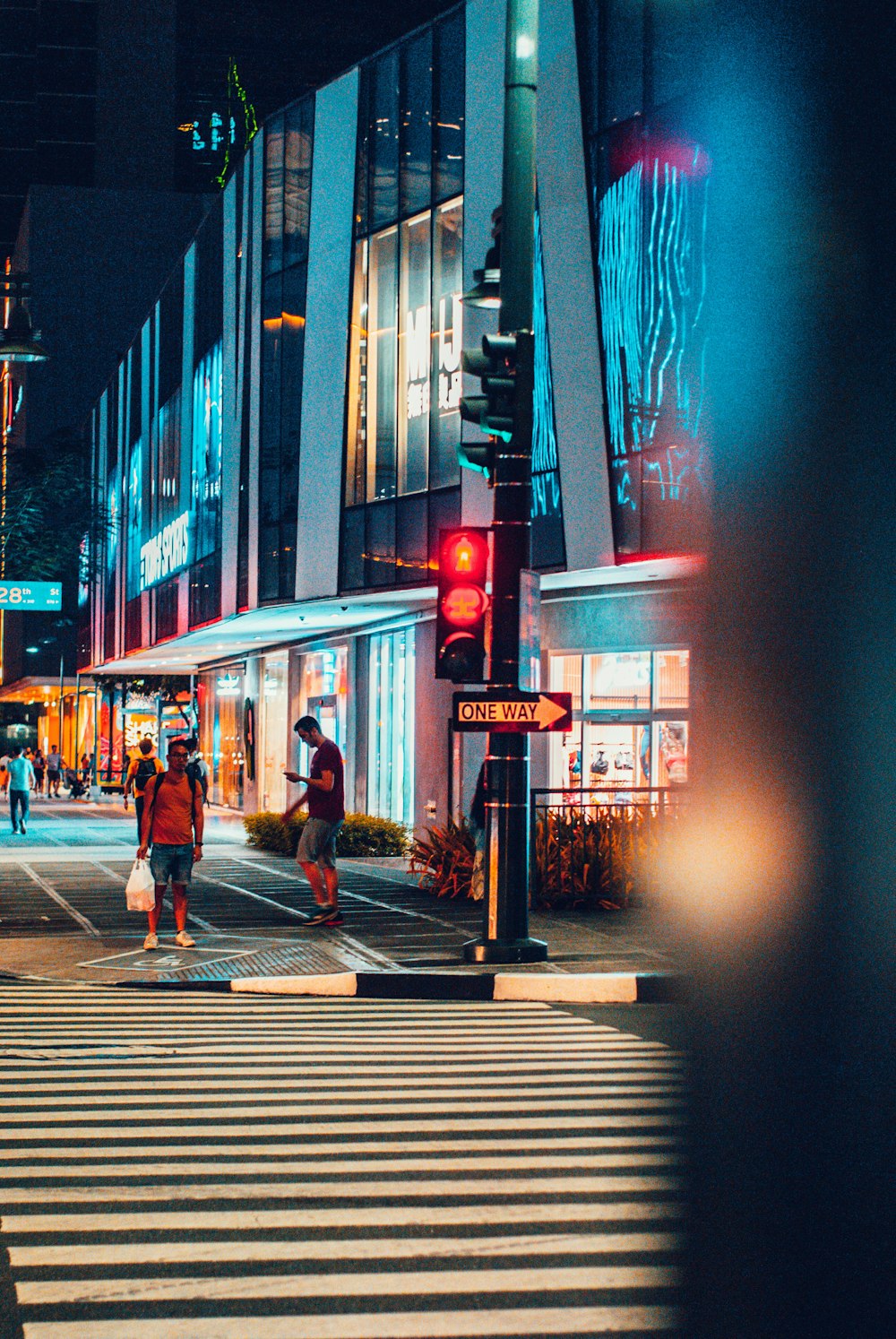 woman in black jacket walking on sidewalk during nighttime