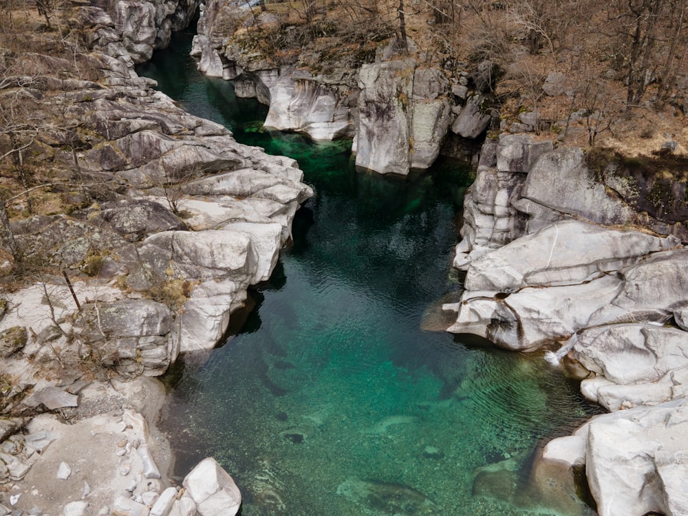 body of water between brown rocky mountain during daytime