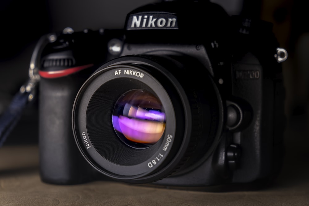 Schwarze Nikon DSLR-Kamera auf braunem Holztisch