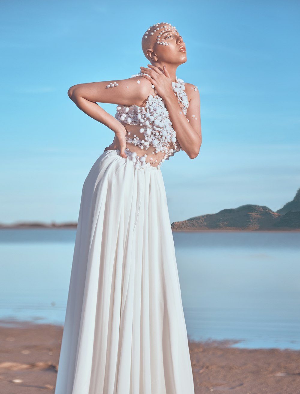 woman in white dress standing on beach during daytime