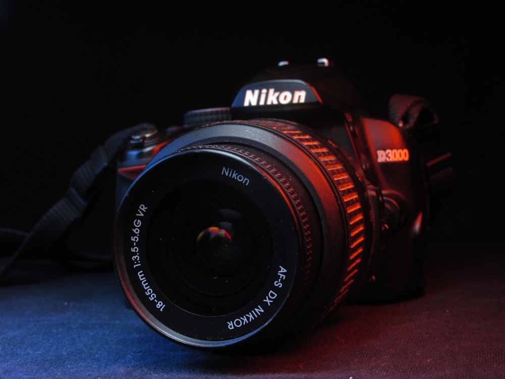 black nikon dslr camera on blue textile