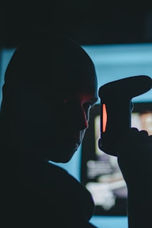 Close-up of a Sentinel agent's hand holding a communication device against a dark background with red accents.