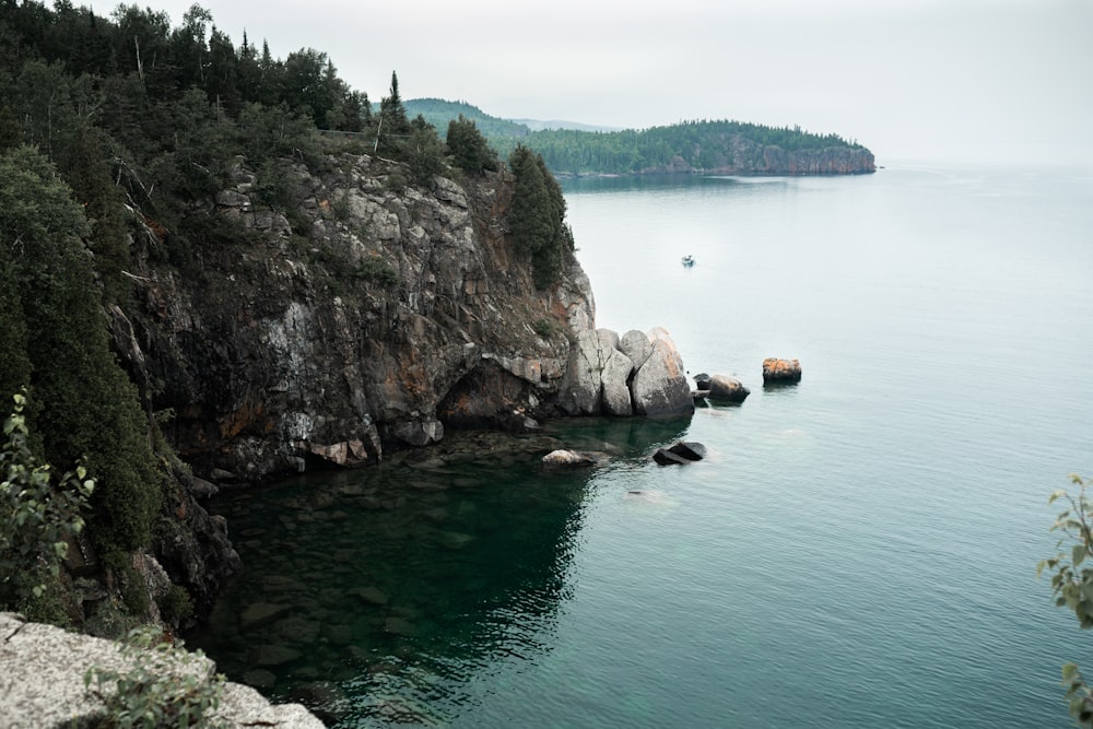 brown rock formation on body of water during daytime