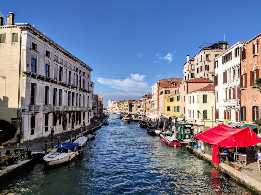 boat on river between buildings during daytime