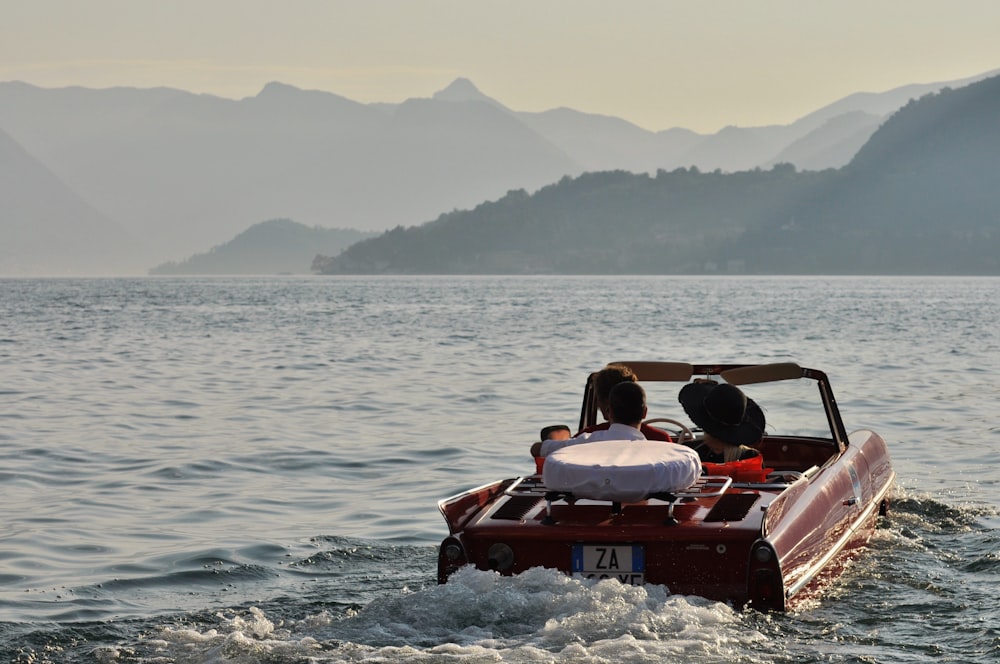 昼間の水上の赤いオープンカー