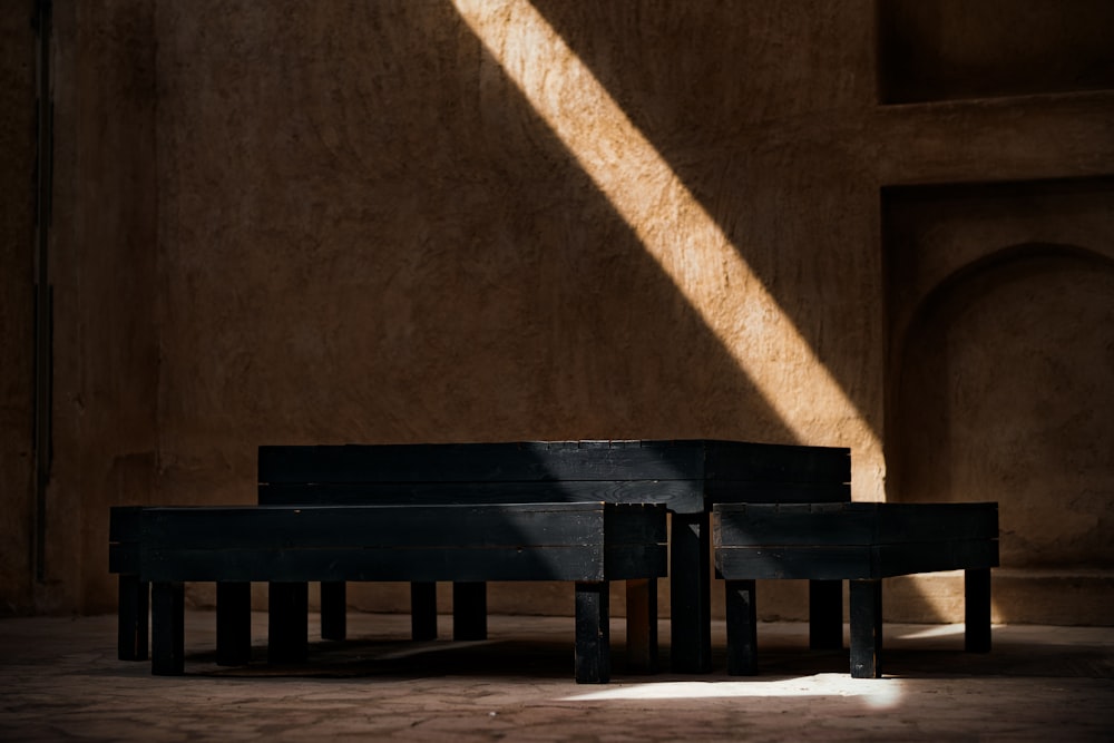 brown wooden bench near brown concrete wall