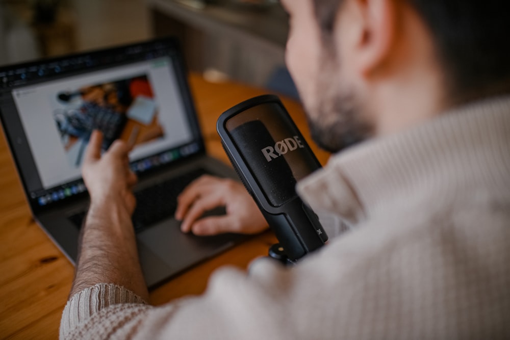 man in white shirt using black laptop computer