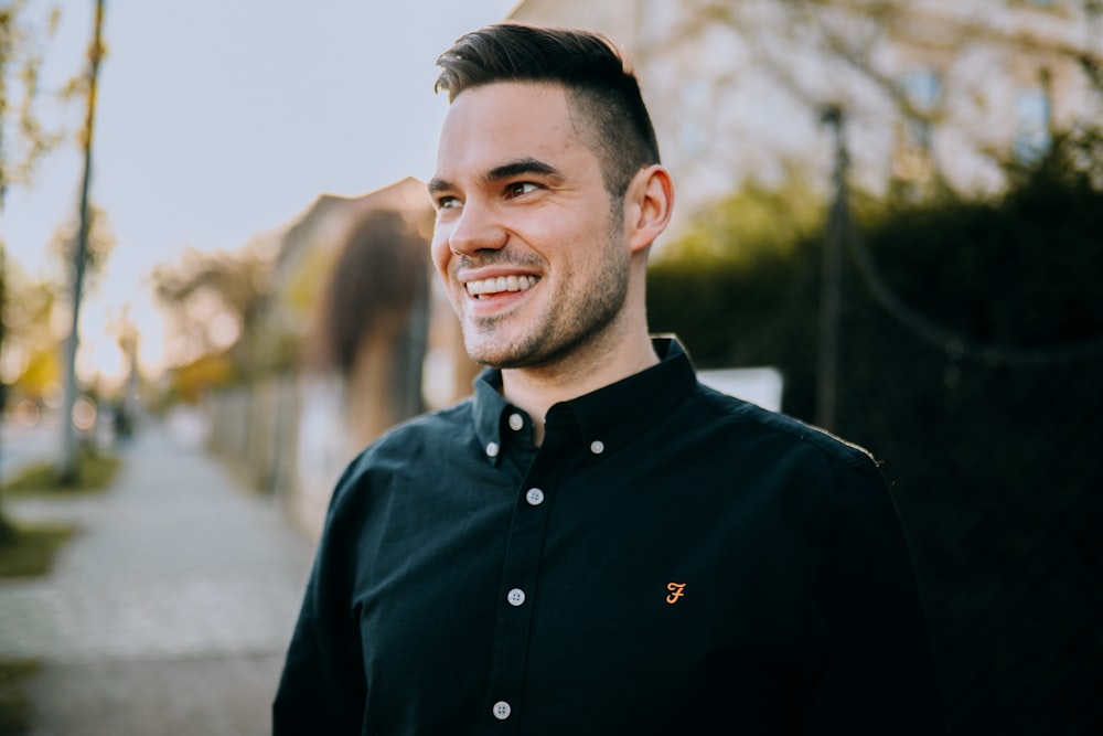 man in black button up shirt smiling