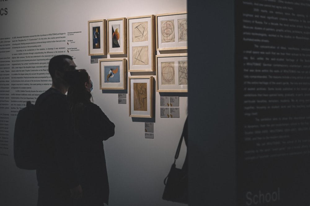 Frau im schwarzen Mantel in der Nähe der Wand