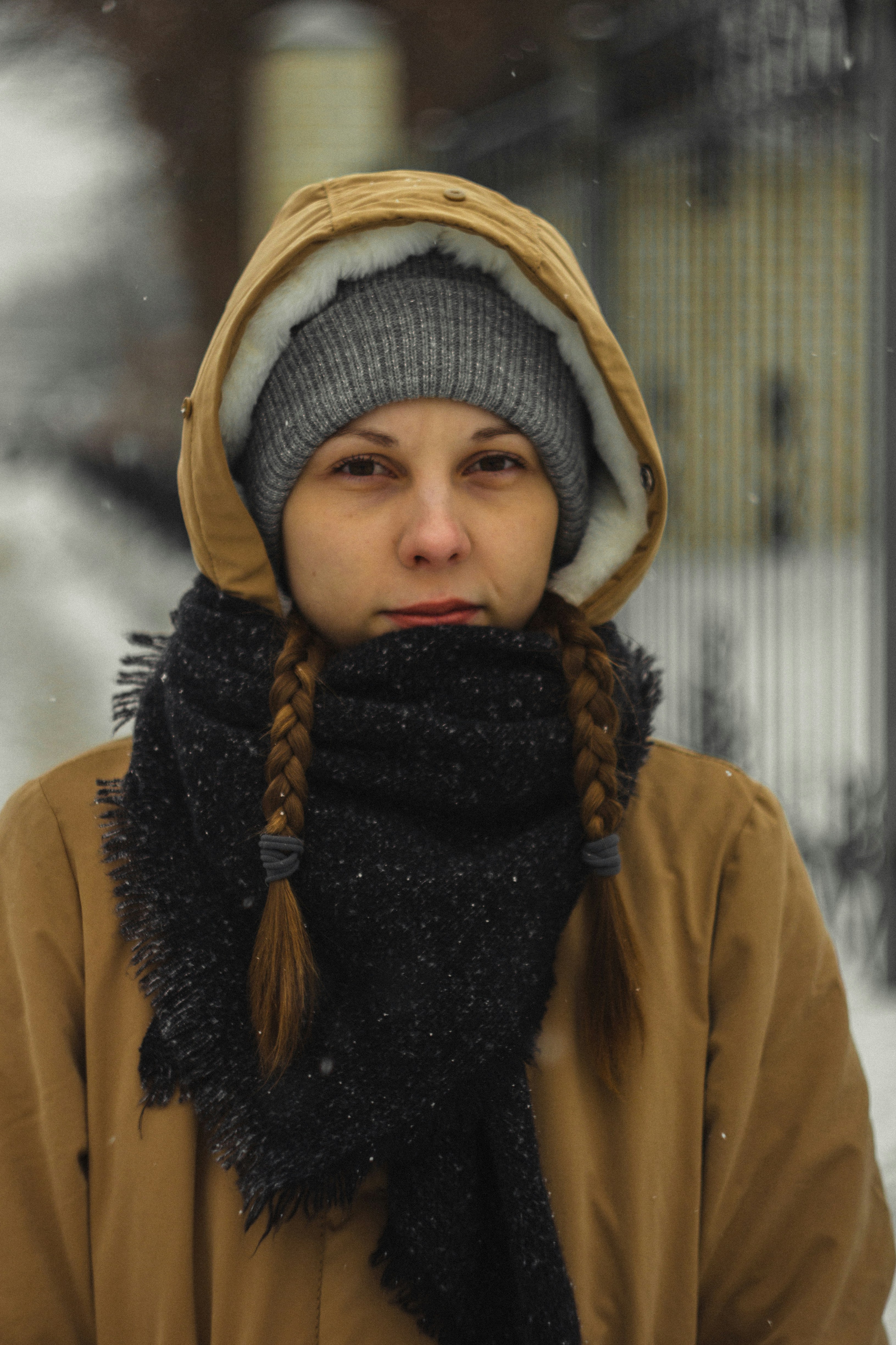 Girl in yellow hoodie standing on snow covered ground during daytime