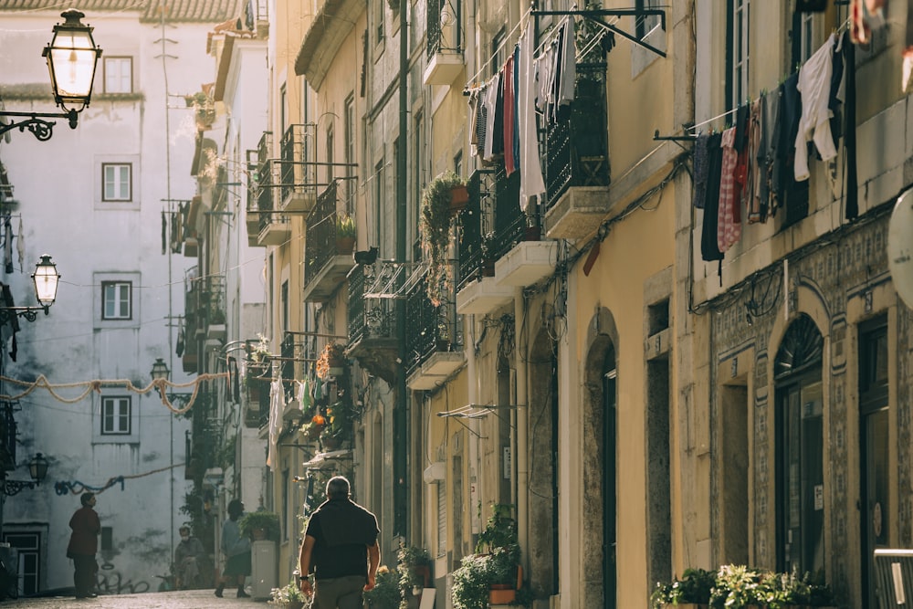 man in black hat walking on street during daytime